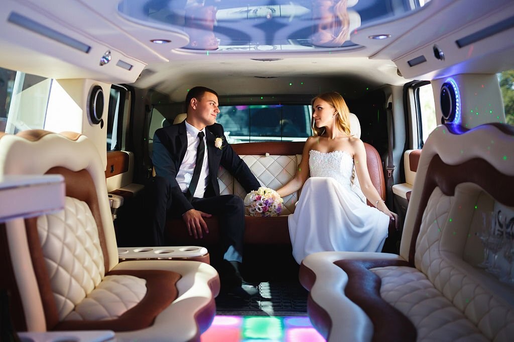 A bridal and groom sitting in the wedding car